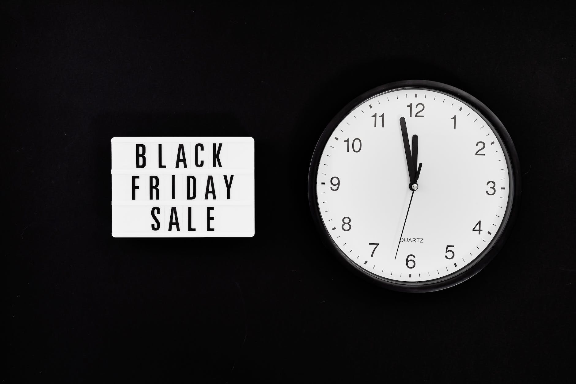 a black friday sale signage beside a black and white round analog wall clock